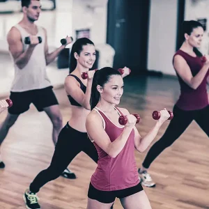 Verschiedene Personen beim Sportkurs mit zwei Hanteln in der Hand